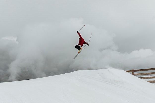 Long shot skier jumping over hill