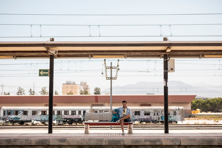 Free Photo long shot smiling traveler waiting for train 