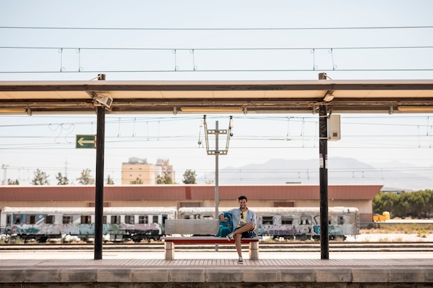 Long shot smiling traveler waiting for train 