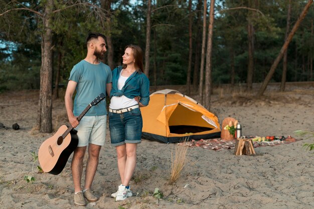 テントの横にあるロングショット立っているカップル