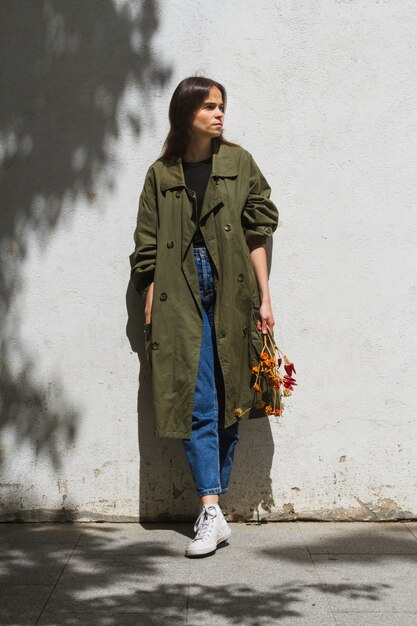 Long shot standing woman holding a bunch of peppers