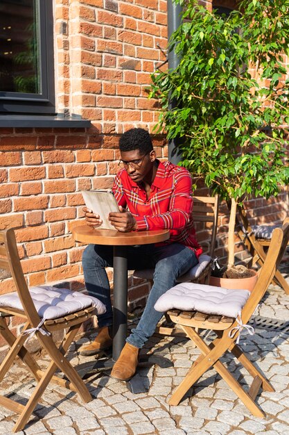 Long shot of stylish man reading