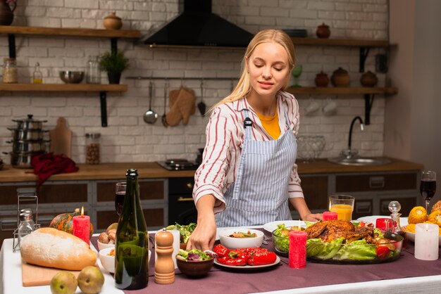 Long shot of woman arranging food in the kitchen