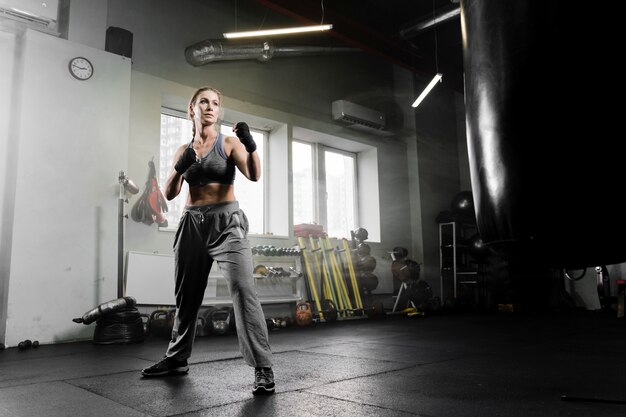 トレーニングセンターでボクシングロングショット女性