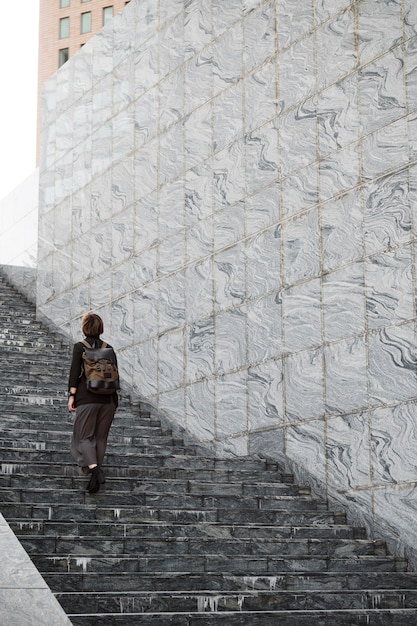 Long shot woman climbing up stairs