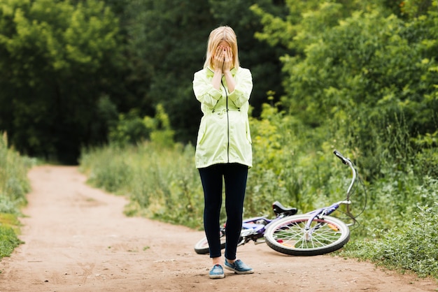 Long shot woman covering her face