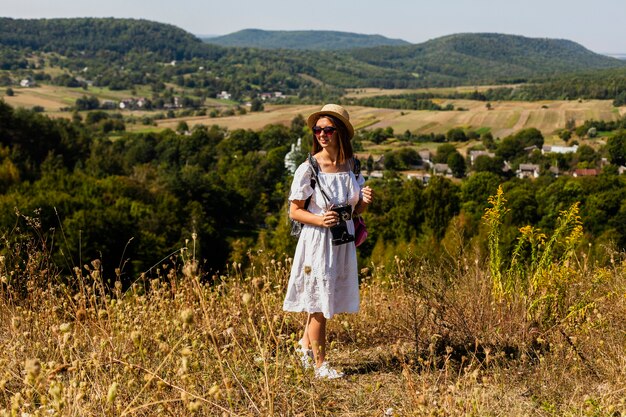 Long shot of woman looking away with natural landscape