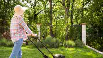 Free photo long shot woman mowing the grass