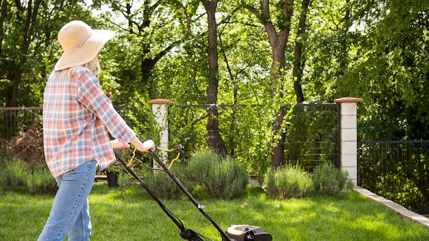草を刈るロングショットの女性