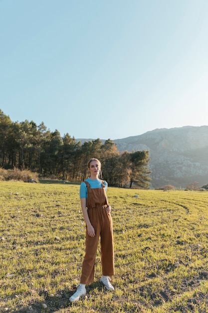 Long shot woman posing in overall