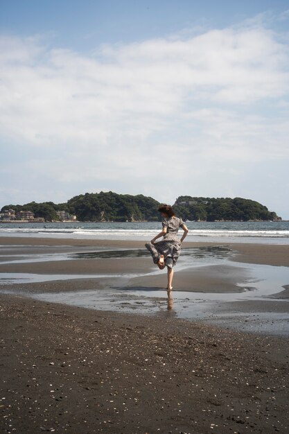 Long shot woman running on beach