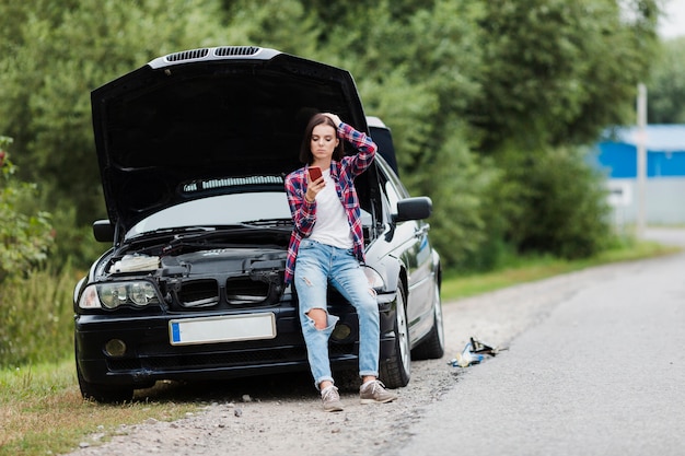 Long shot of woman sitting on car