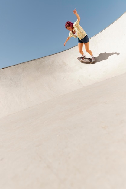 Long shot woman on skateboard outdoors