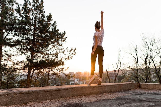 Long shot woman in sportswear being victorious