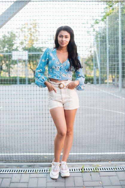 Long shot of woman standing next to a basketball field