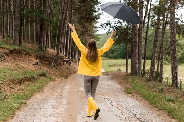 Long shot woman taking a walk in the forest