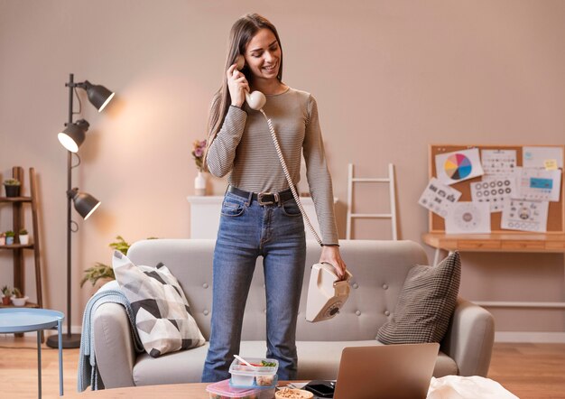 Long shot of woman talking on an old telephone