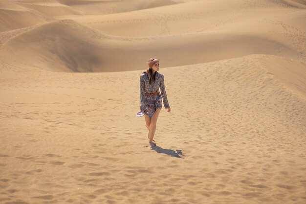 Long shot woman walking in desert