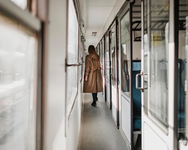 long shot of woman walking on the train corridor