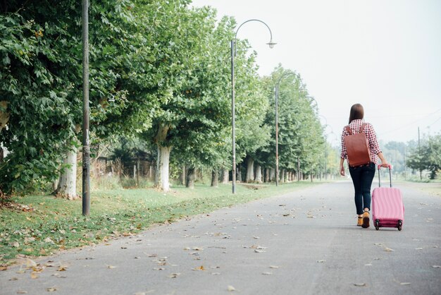 Long shot of woman with her luggage