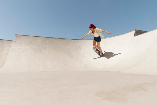 Long shot woman with skateboard outside