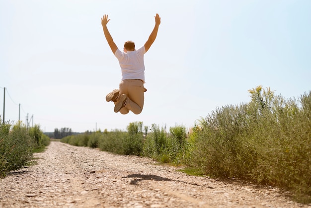 Free photo long shot of a young man jumping in the air