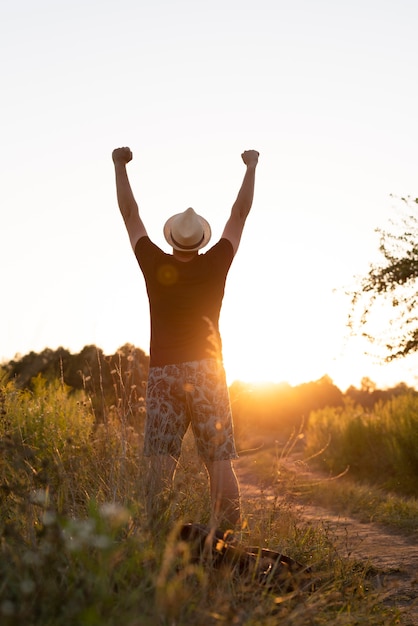 Free photo long shot of a young man rising his arms