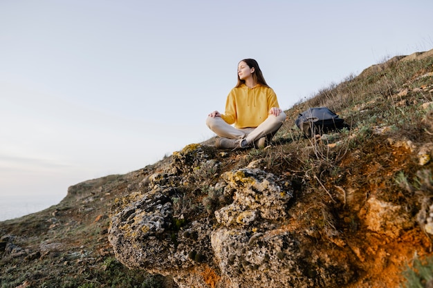 Foto gratuita colpo lungo di giovane donna che gode della natura intorno a lei