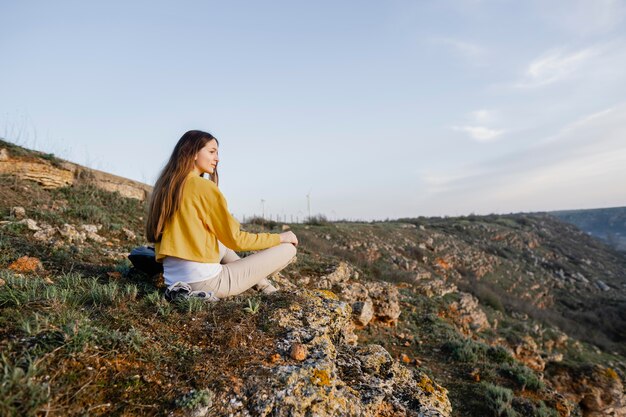 Long shot of young woman enjoying the nature around her