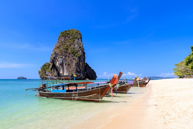 프라낭 비치 크라비 태국(Phra Nang Beach Krabi Thailand)의 롱테일 보트와 석회암 절벽과 산이 있는 청록색 수정처럼 맑은 바닷물
