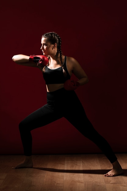 Foto gratuita lunga vista lateralmente della donna atletica in abiti fitness