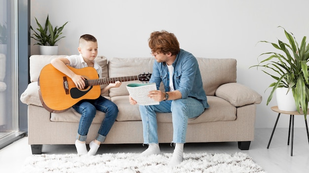 Long view student and teacher playing guitar