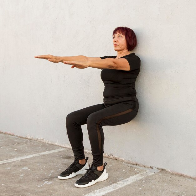 Long view of woman doing wall stand exercise