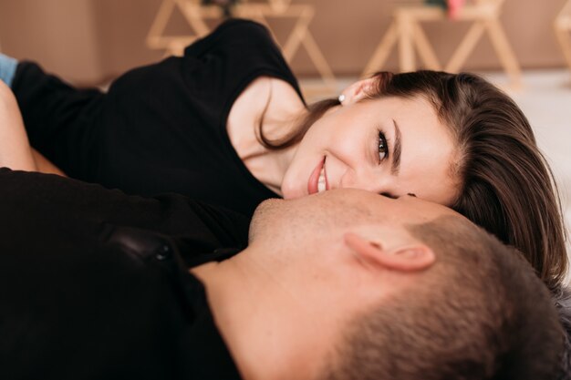 Look from above at happy young couple in black t-shirts lying 