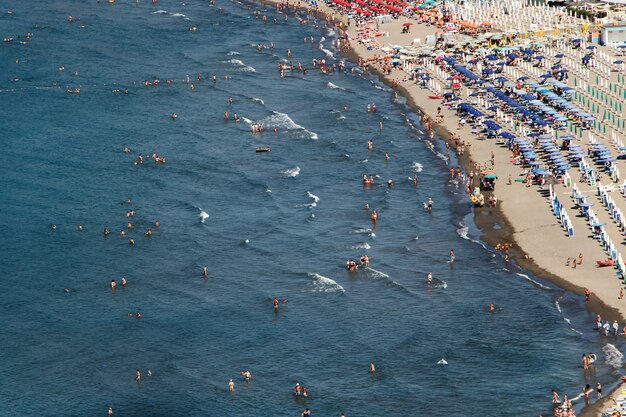 Взгляните сверху на людей, отдыхающих на золотом пляже