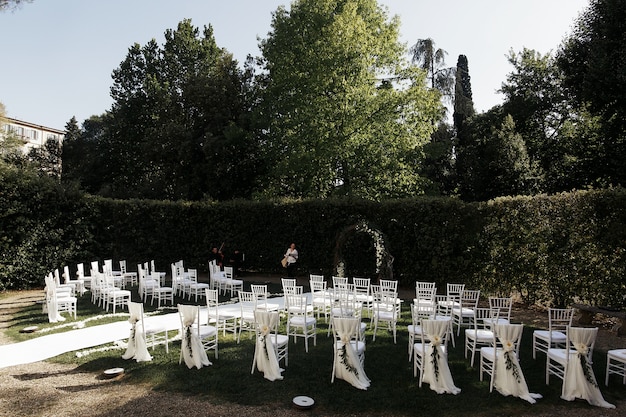 Free photo look from behind at white chairs arranged for wedding ceremony