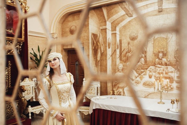 Look through the bars at young princess in fancy clothes