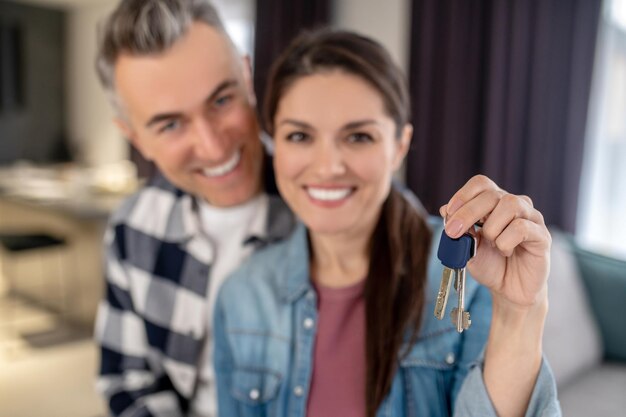 Looking at camera man and woman showing keys