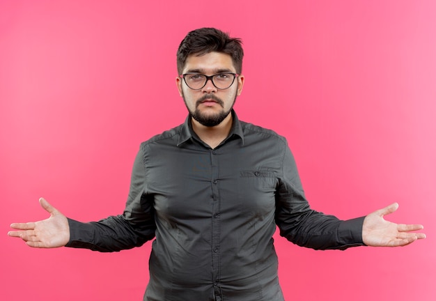 Free photo looking at camera young businessman wearing glasses holding out hands to sides