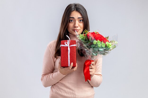 Looking camera young girl on valentines day holding gift box with bouquet isolated on white background