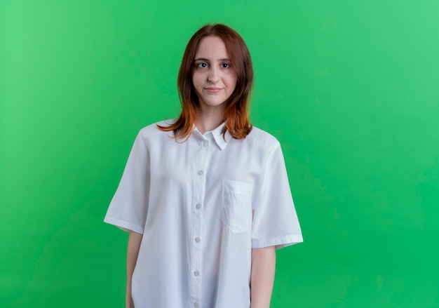 Looking at camera young redhead girl isolated on green background