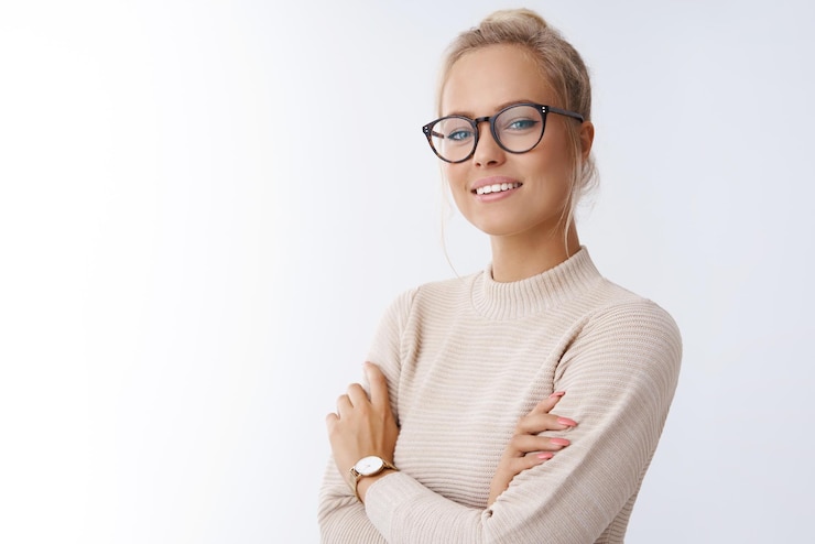 Free Photo looking like professional attractive successful and confident female entrepreneur with blond hair in glasses knowing how deal with job cross arms against chest in selfassured over white wall