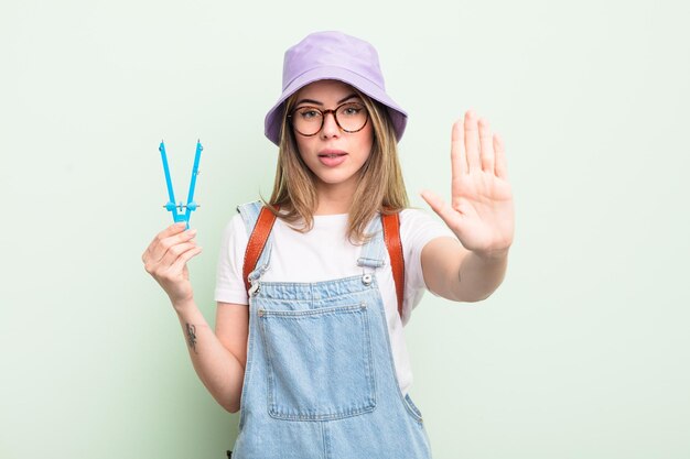 중지 제스처를 만드는 열린 손바닥을 보여주는 심각한 찾고