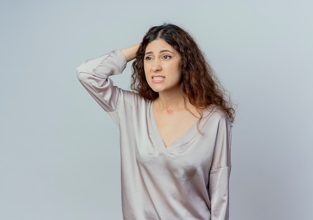 Looking at side concerned young pretty female office worker putting hand on head isolated on white background