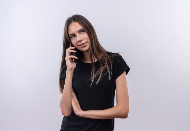 Looking at side young caucasian girl wearing black t-shirt speaks on phone on isolated white background