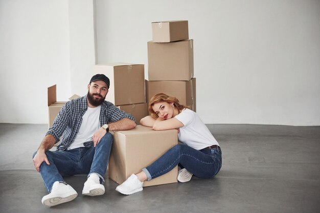 Looking straight into the camera. Happy couple together in their new house. Conception of moving