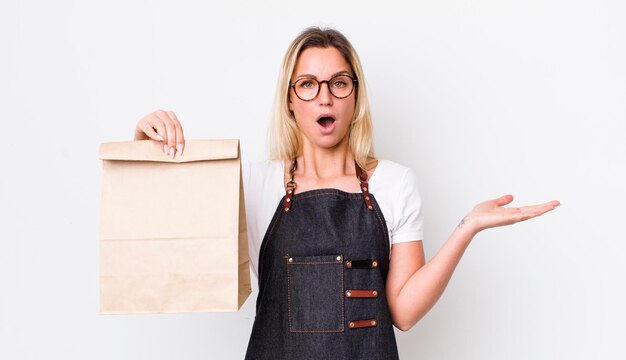 Looking surprised and shocked with jaw dropped holding an object