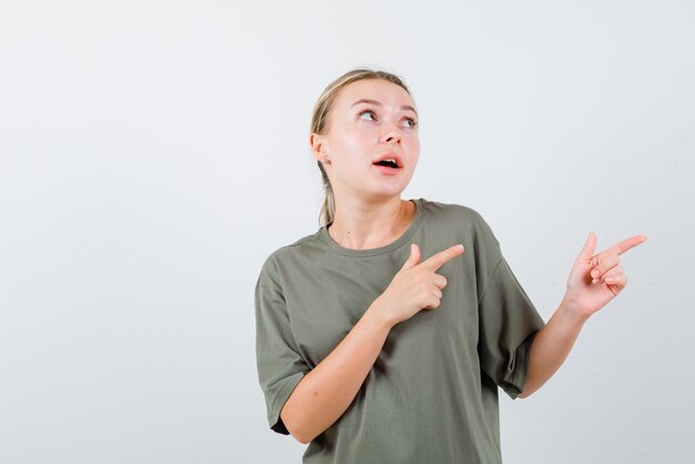 The looking up bonde woman is pointing to right with forefingers  on white background