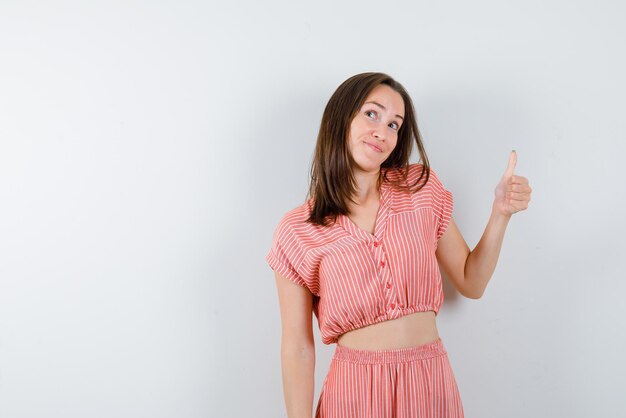 The looking up woman is showing perfect gesture with thumb on white background
