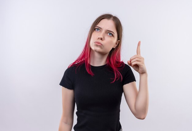 Looking at up young beautiful girl wearing black t-shirt points finger to up on isolated white background